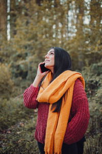 Young woman talking with smartphone in the forest