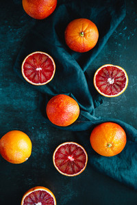 Flat lay food composition with blood oranges on a dark blue background