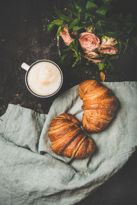 Coffee break with cappuccino  croissants and spring flowers