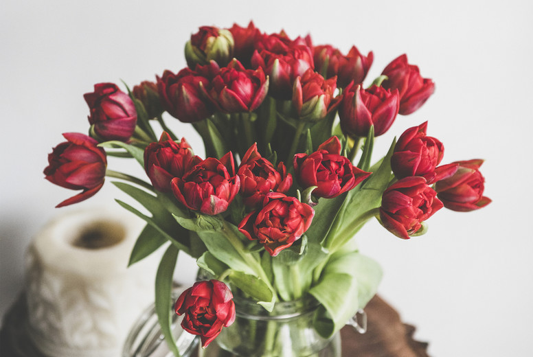 Bouquet of fresh Spring red tulips on rustic wooden table