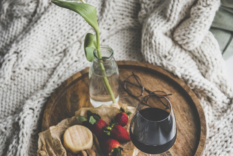Glass of red wine, different snacks and tulip in jar