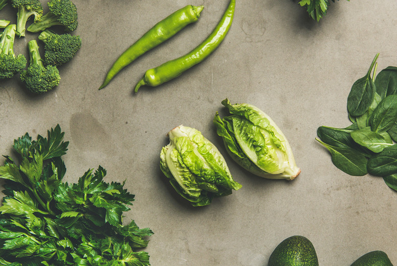 Healthy vegan ingredients layout over concrete table background, narrow composition