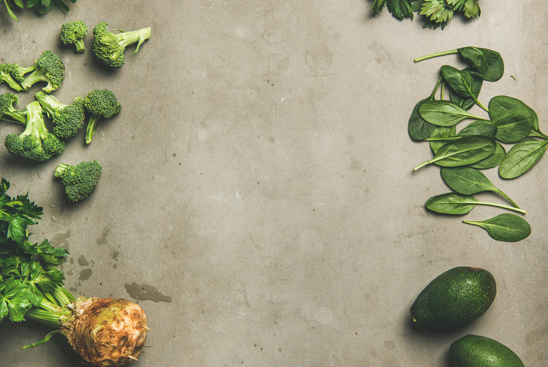 Healthy vegan ingredients layout over concrete table background, vertical composition
