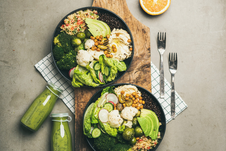 Flat-lay of healthy dinner with superbowls on board and smoothies
