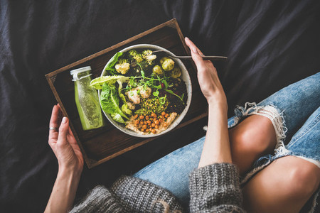 Healthy vegan bowl in bed  smoothie and woman in jeans