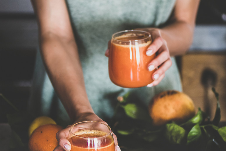 Woman holding glasses with fresh blood orange juice