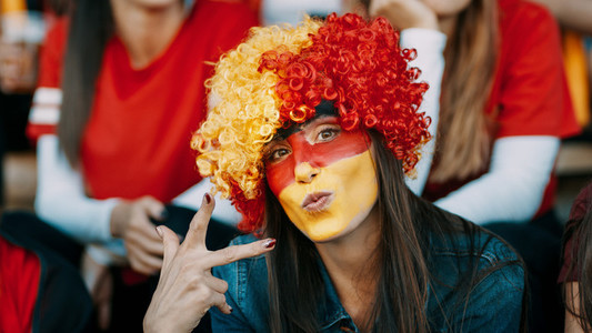 German soccer supporter in stadium with victory sign
