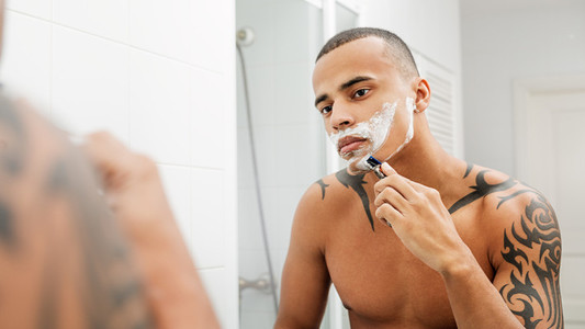 Mixed race person shaving