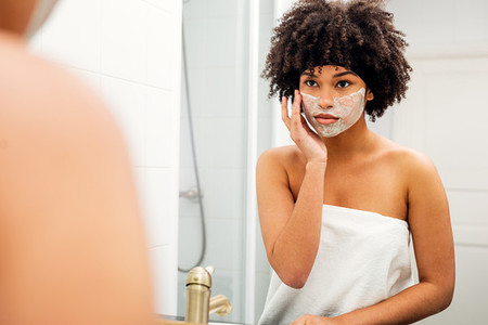 Woman applying facial mask