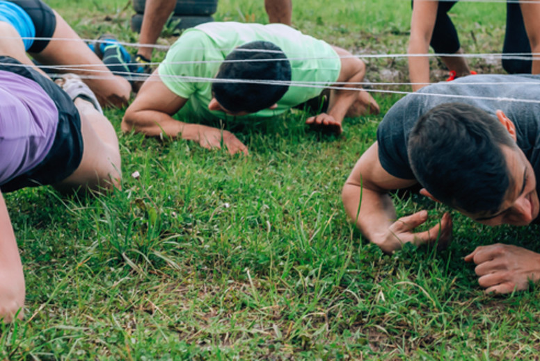 Participants in an obstacle course crawling
