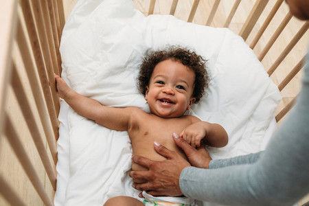 Happy baby boy in a crib