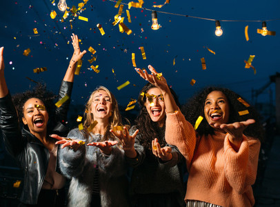 Happy women throwing confetti