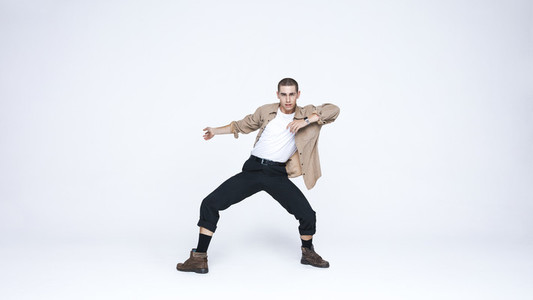 Young man dancing against white background