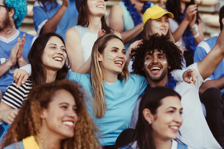 Happy Argentinian soccer fans watching a match in stadium