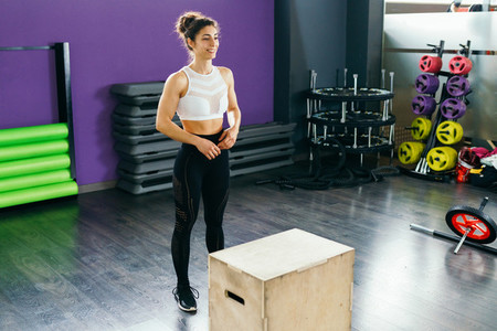 Fitness woman jumping onto a box as part of exercise routine