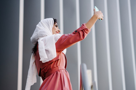 Arab Woman with hijab taking selfie with smartphone