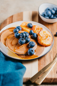 Close up of pancakes with grilled peaches fresh blueberry and honey