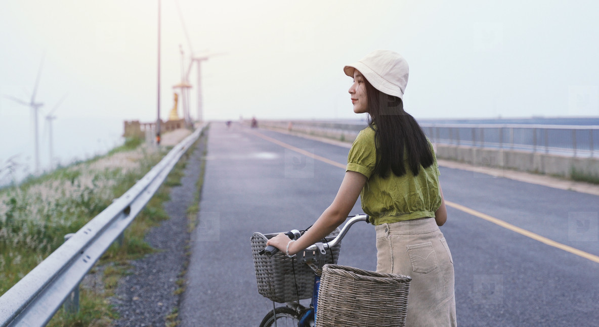 Young asian millennial woman with bicycle feeling relax while tr