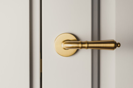 Brushed gold modern design in vintage style door handle on a white door