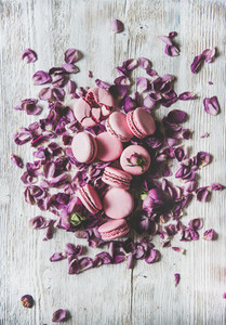 Sweet macaron cookies heap and rose buds and petals