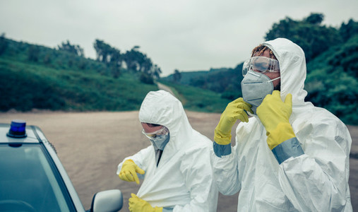 Two young people putting on bacteriological protection suits