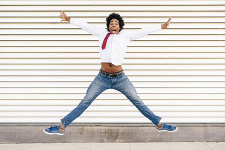 Black Businessman jumping outdoors  Man with afro hair