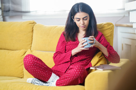 Woman at home having tea and reading