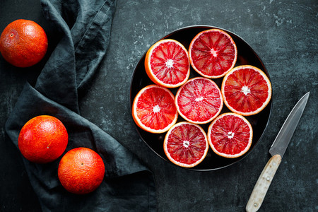 Cutted blood oranges in a plate on a black background