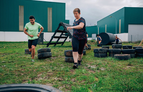 Participants in an obstacle course dragging wheels