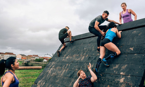 Participants in obstacle course climbing pyramid obstacle