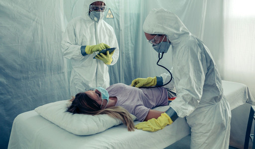 Doctors with bacteriological protection suits attending a patien