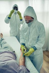 Doctors injecting a vaccine to a patient