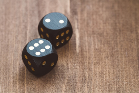 Close up of black dice on a wooden table