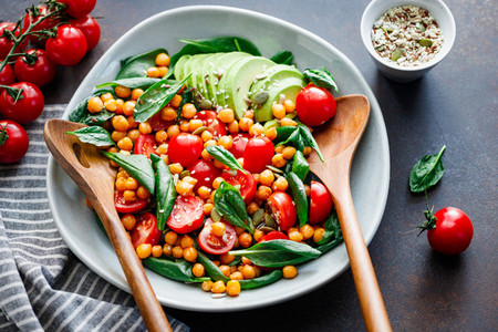 Fresh healthy salad with chickpea avocado cherry tomatoes and spinach