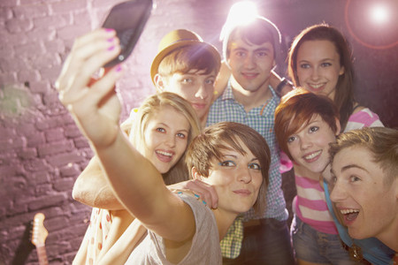 Happy teenage friends taking selfie at party