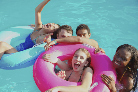 Portrait playful teenage friends enjoying pool party
