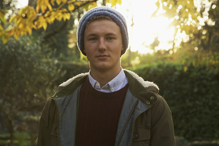 Portrait confident teenage boy in autumn park