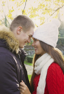 Happy teenage couple head to head in autumn park