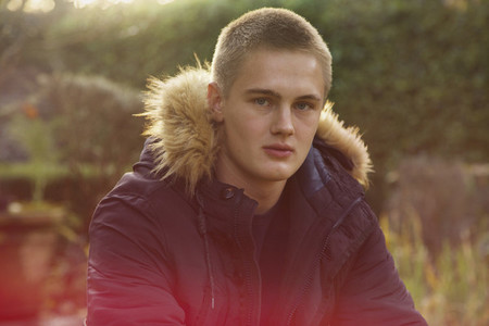Portrait confident teenage boy in jacket