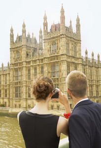 Young couple with camera photographing Houses of Parliament