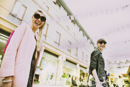 Portrait happy young women in sunglasses on urban street