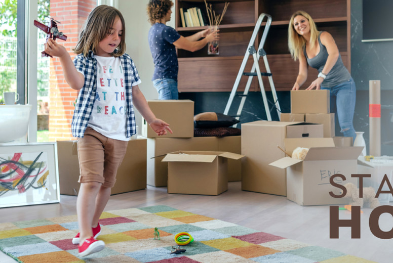 Boy playing with toy airplane while parents unpack