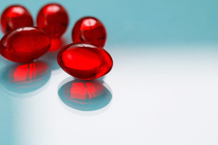 Close up of red painkiller pills on a blue background