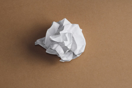 Top view of the ball of crumpled white paper on a kraft background