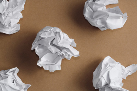 Top view of balls of crumpled white paper on a kraft background