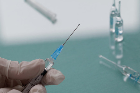 Doctor holding a syringe with a transparent injection  Close up