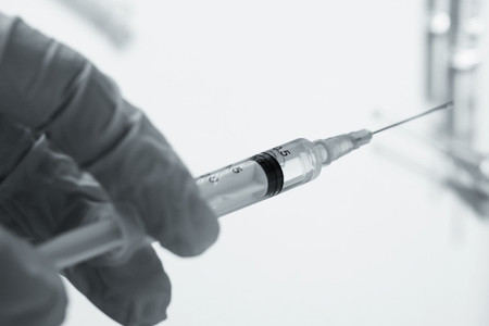 Doctor holds a syringe