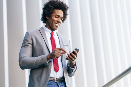 Black Businessman using a smartphone near an office building