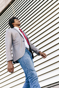 Black Businessman wearing suit walking in urban background