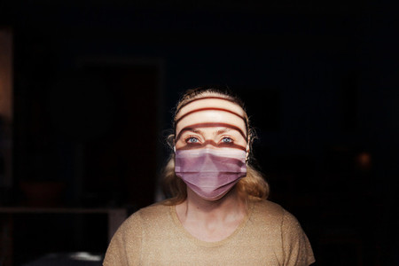 Woman wearing a surgical mask during quarantine in her houses